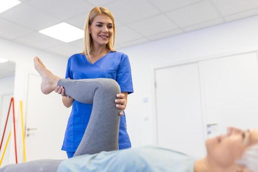 Physiotherapist stretching a patient's leg during rehabilitation