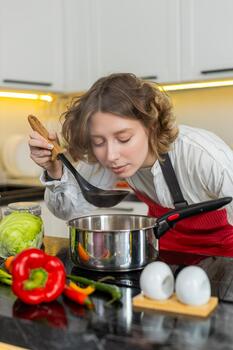 Woman cooking a fresh vegetable soup in her kitchen
